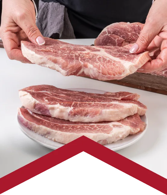 butcher handling fresh pork cuts